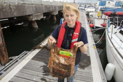 Imogen Napper, the study's lead author, demonstrates that even after years underwater, bags billed as biodegradable can still hold a load of groceries. Image courtesy of the University of Plymouth