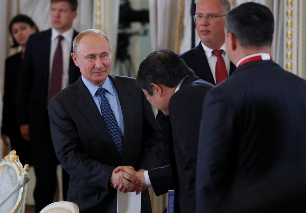 Russian President Vladimir Putin shakes hands with a participant at a meeting with members of the RDIF and representatives...