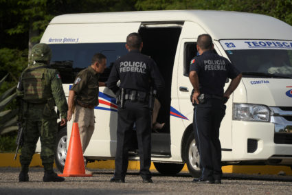 A National Migration Institute agent conducts a check on passengers as a member of the National Guard and federal policemen keep watch at a checkpoint in Comitan, in Chiapas state, Mexico on June 16, 2019. Photo by Isabel Mateos/Reuters