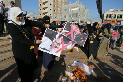 Palestinian women burn posters depicting U.S. President Donald Trump and Israeli Prime Minister Benjamin Netanyahu during a protest against Bahrain's workshop for U.S. peace plan, in the southern Gaza Strip on June 18, 2019. Photo by Ibraheem Abu Mustafa/Reuters