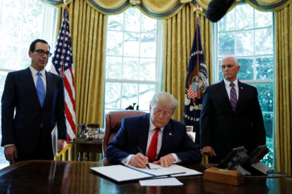 President Donald Trump signs an executive order imposing fresh sanctions on Iran as Treasury Secretary Steven Mnuchin and Vice President Mike Pence look on in the Oval Office of the White House in Washington, on June 24, 2019. Photo by Carlos Barria/Reuters