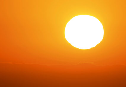 A U.S. military helicopter travels over the pacific ocean past a setting sun near Cardiff, California June 24, 2015. Photo by REUTERS/Mike Blake