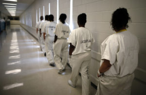 Women walk along a corridor at the Los Angeles County women's jail in Lynwood, California April 26, 2013. The Second Chance Women's Re-entry Court is one of the first in the U.S. to focus on women, and offers a cost-saving alternative to prison for women who plead guilty to non-violent crimes and volunteer for treatment. Of the 297 women who have been through the court since 2007, 100 have graduated, and only 35 have been returned to state prison. Photo by Lucy Nicholson/Reuters