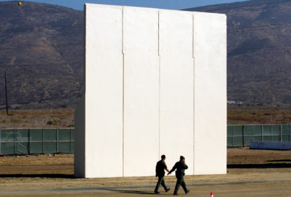 U.S. border patrol officers walk near a prototype for U.S. President Donald Trump's border wall with Mexico, in this picture taken from the Mexican side of the border, in Tijuana, Mexico, October 26, 2017. Photo Jorge Duenes/Reuters
