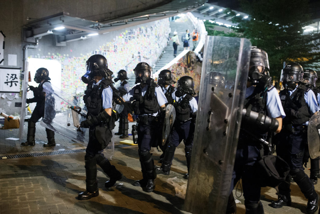 Riot police clear the streets outside the Legislative Council building, after protesters stormed the building on the anniv...