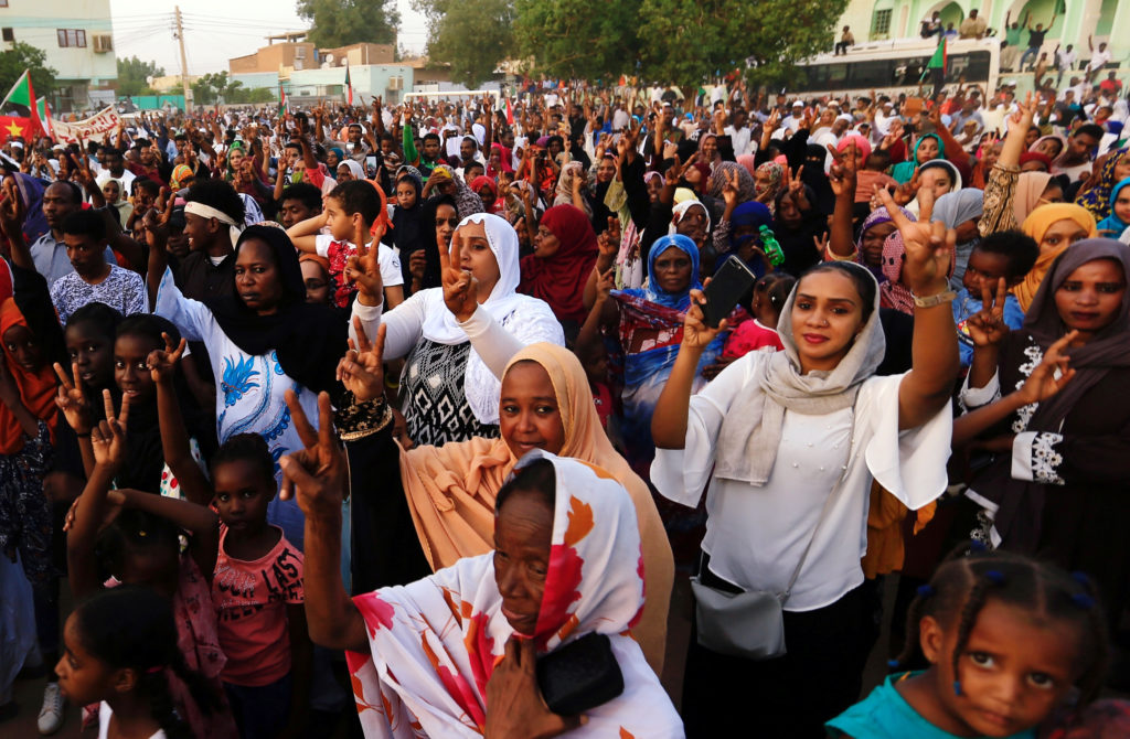 Sudanese people chant slogans as they celebrate, after Sudan's ruling military council and a coalition of opposition and p...