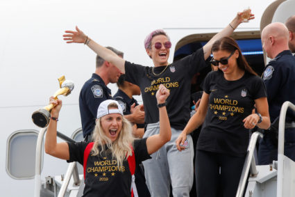U.S. soccer players Julie Ertz (left), Megan Rapinoe (center) and Alex Morgan celebrate as they exit the plane with the Trophy for the FIFA Women's World Cup while the U.S team arrive at the Newark International Airport, in Newark, New Jersey, on July 08, 2019. Photo by Eduardo Munoz/Reuters
