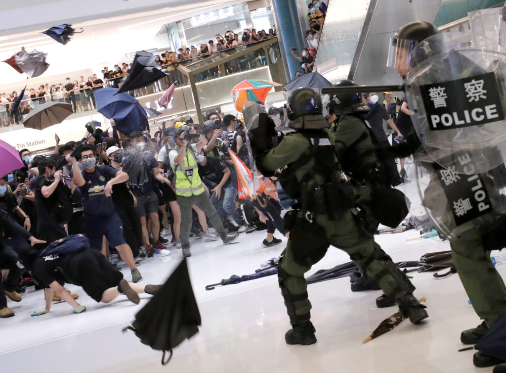 Riot police use pepper spray to disperse pro-democracy activists inside a mall after a march at Sha Tin District of East N...