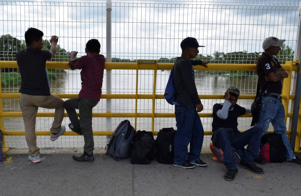 Migrants queue to request humanitarian visas to enter Mexico at the Rodolfo Robles international border crossing bridge, t...