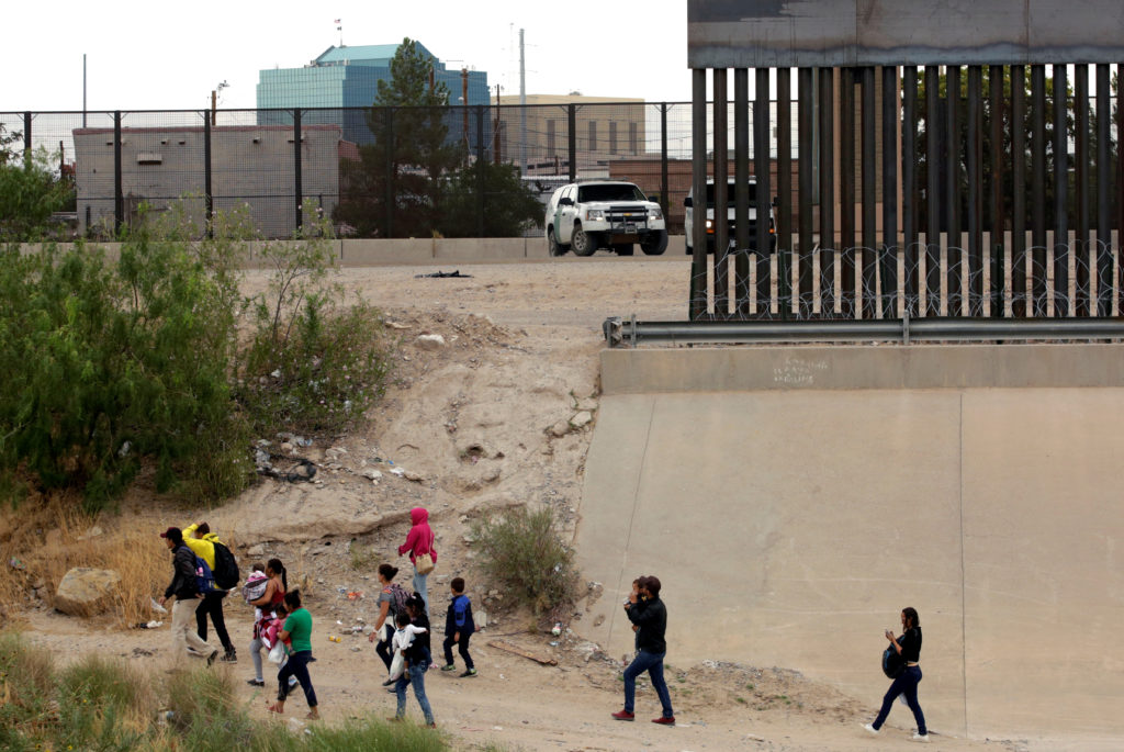 Migrants are seen after crossing illegally into El Paso, Texas, U.S., as seen from Paso del Norte border crossing bridge i...