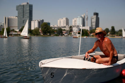 A man steers a boat at Alte Donau, an abandoned meander of river Danube during a heat wave in Vienna, Austria on July 25, 2019. Photo by Lisi Niesner/Reuters