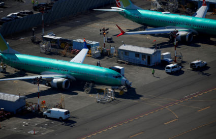 A worker walks past unpainted Boeing 737 MAX aircraft seen parked in an aerial photo at Renton Municipal Airport near the Boeing Renton facility in Renton, Washington, U.S. July 1, 2019. Picture taken July 1, 2019. Photo by: Lindsey Wasson/Reuters