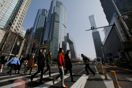 People cross a street in the Central Business District (CBD) one day before the opening session of the National People's Congress (NPC) in Beijing, China on March 4, 2019. Photo by Thomas Peter/Reuters