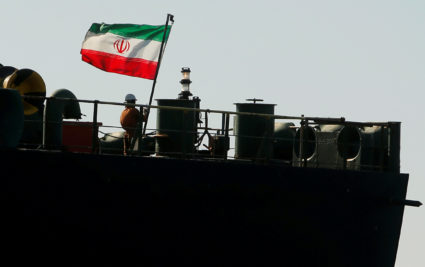 A crew member raises the Iranian flag on Iranian oil tanker Adrian Darya 1, previously named Grace 1, as it sits anchored after the Supreme Court of the British territory lifted its detention order, in the Strait of Gibraltar, Spain, on August 18, 2019. Photo by Jon Nazca/Reuters