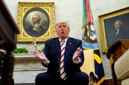 U.S. President Donald Trump answers questions while sitting in front of paintings of former U.S. presidents George Washington and Thomas Jefferson during his meeting with Romania's President Klaus Iohannis in the Oval Office of the White House in Washington, U.S. August 20, 2019. Photo by: Kevin Lamarque/Reuters
