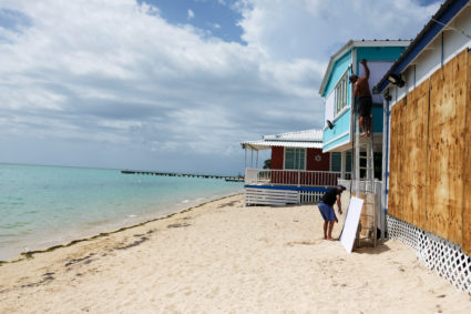 A man boards up the windows of a beach house in the tourist zone of El Combate as Tropical Storm Dorian approaches in Cabo Rojo, Puerto Rico August 27, 2019. Photo by Ricardo Arduengo/Reuters