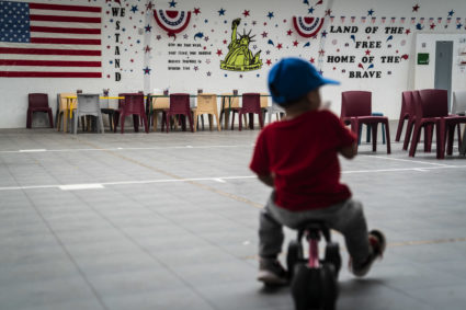 An immigrant child plays in front of patriotic phrases and symbols covering the walls in a gymnasium as U.S. Immigration and Customs Enforcement (ICE) and Enforcement and Removal Operations (ERO) hosts a media tour at the South Texas Family Residential Center, which houses families who are pending disposition of their immigration cases on Friday, Aug. 23, 2019 in Dilley, TX. (Photo by Jabin Botsford/The Washington Post via Getty Images)