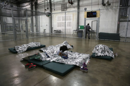 A girl from Central America rests on thermal blankets at a detention facility run by the U.S. Border Patrol on September 8, 2014 in McAllen, Texas. The Border Patrol opened the holding center to temporarily house the children after tens of thousands of families and unaccompanied minors from Central America crossed the border illegally into the United States during the spring and summer. Although the flow of underage immigrants has since slowed greatly, thousands of them are now housed in centers around the United States as immigration courts process their cases. (Photo by John Moore/Getty Images)