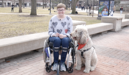 Charlotte Devitz, a researcher, and Fish, a service dog. Image by Sean Moore/University of Michigan News