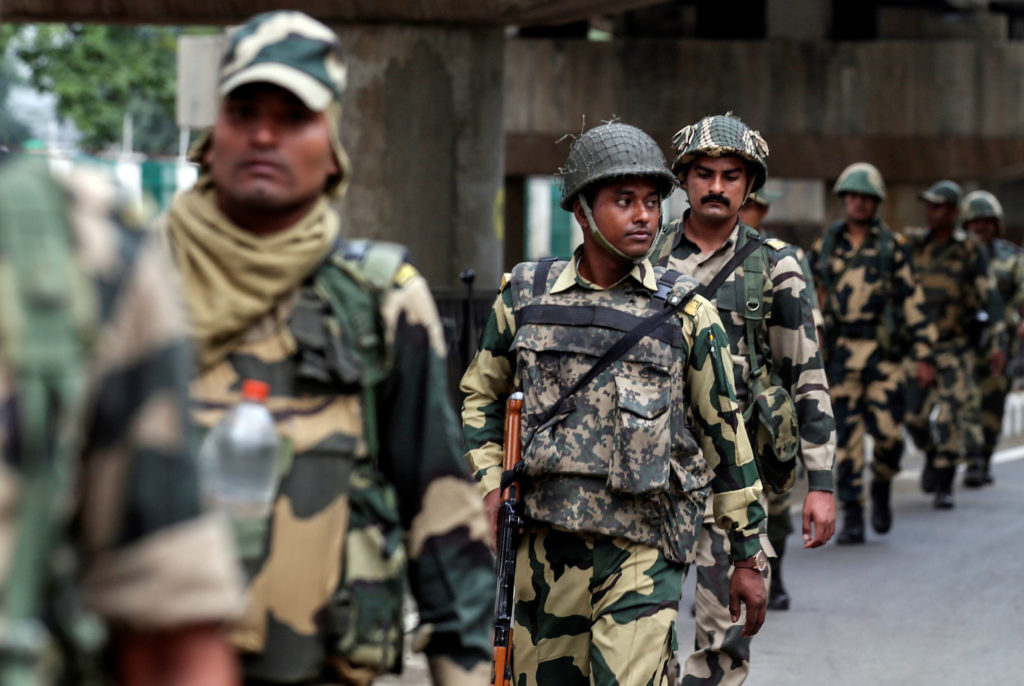 Indian security forces personnel patrol a deserted street during restrictions after the government scrapped special status...