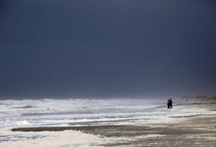 A couple look out at the roiling surf while the skies darken as Hurricane Dorian approaches, in Carolina Beach, North Carolina, on September 5, 2019. Photo by Jonathan Drake/Reuters