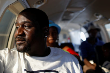 A man looks down through an airplane window as the plane takes off during an evacuation operation after Hurricane Dorian hit the Abaco Islands in Marsh Harbour, Bahamas, September 8, 2019. Photo by Marco Bello/Reuters