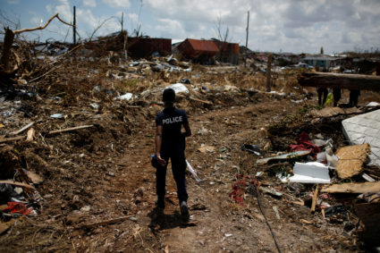 A police officer searches for the dead in the destroyed Mudd neighborhood after Hurricane Dorian hit the Abaco Islands in Marsh Harbour, Bahamas, September 10, 2019. Photo by Marco Bello/Reuters