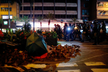 Riot police walk past a barrier after a clash with anti-government protesters in Hong Kong on September 29, 2019.