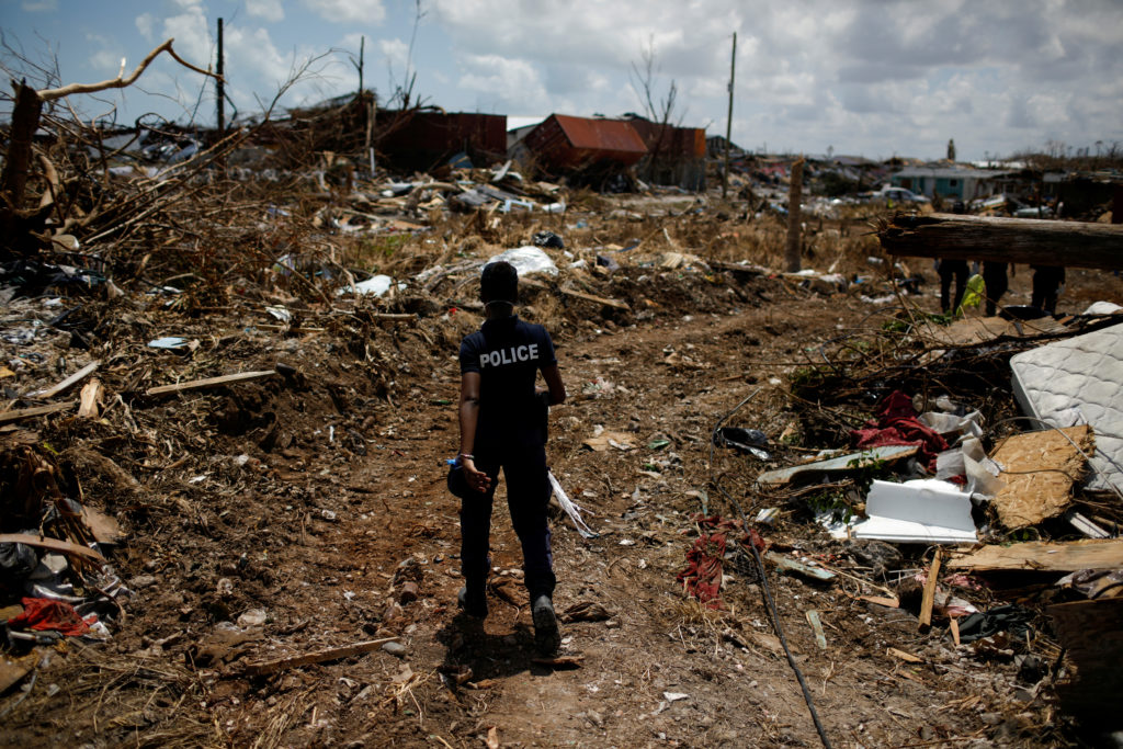 A police officer searches for the dead in the destroyed Mudd neighborhood after Hurricane Dorian hit the Abaco Islands in ...