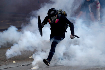 An anti-government protester runs through a cloud of tear gas during a protest in Sham Shui Po district, on China's National Day in Hong Kong, China on October 1, 2019. Photo by Athit Perawongmetha/Reuters