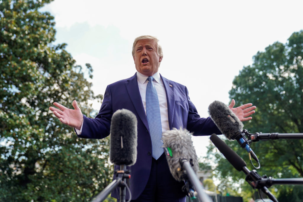 U.S. President Donald Trump responds to reporters questions as he heads to the Marine One helicopter to fly to visit injur...