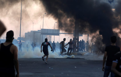 Demonstrators disperse as Iraqi security forces use tear gas during a protest after the lifting of the curfew, following four days of nationwide anti-government protests that turned violent, in Baghdad, Iraq on October 5, 2019. Photo by Thaier Al-Sudani/Reuters