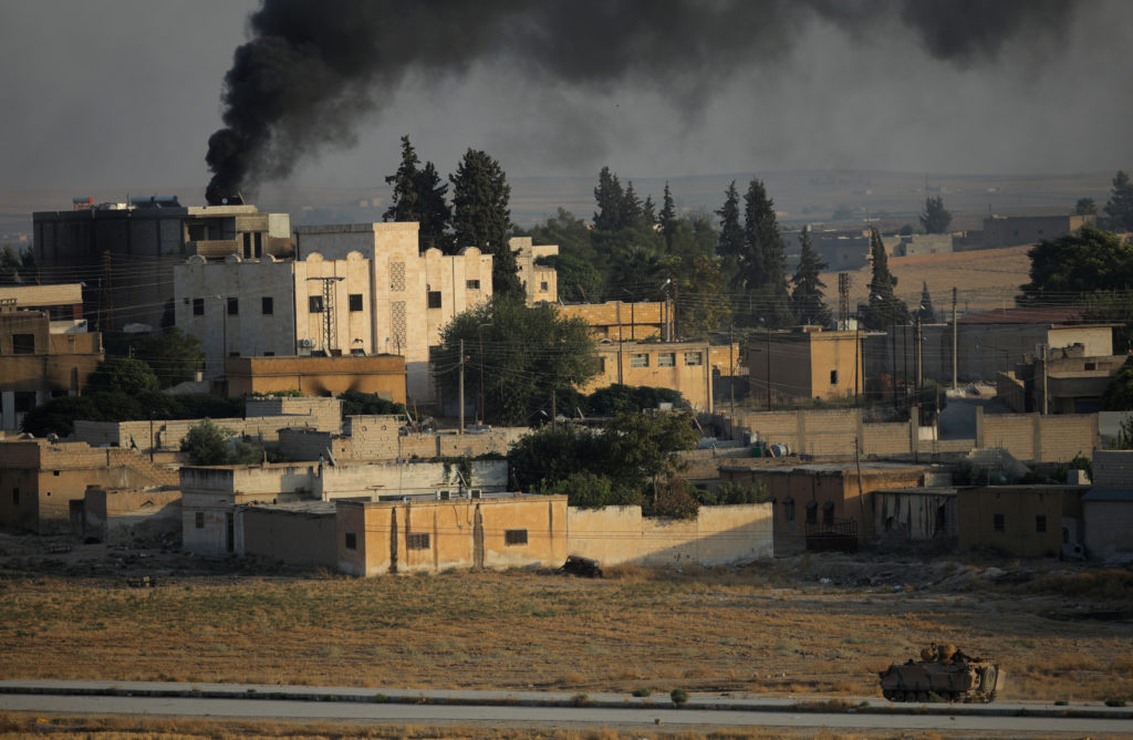 Smoke rises above the Syrian border town of Tel Abyad, as seen from Akcakale, Turkey, October 13, 2019. Photo by Stoyan Ne...