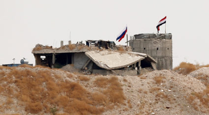 Russian and Syrian national flags are pictured near the northern Syrian village of Zor Magar, as seen from the Turkish border town of Karkamis in Gaziantep province, Turkey, October 23, 2019. Photo by Huseyin Aldemir/Reuters