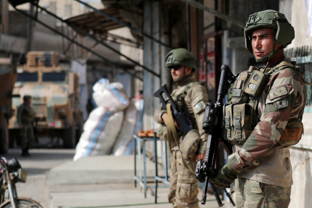 Turkish soldiers stand guard in the town of Tal Abyad, Syria October 23, 2019. Photo by Khalil Ashawi/Reuters