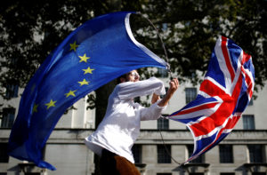 An EU supporter waves flags while other demonstrators march as parliament sits on a Saturday for the first time since the 1982 Falklands War, to discuss Brexit in London, Britain, October 19, 2019. Photo by Henry Nicholls/Reuters