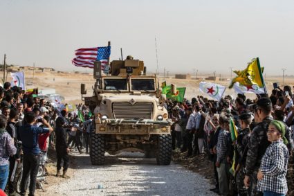 TOPSHOT - Syrian Kurds gather around a US armoured vehicle during a demonstration against Turkish threats next to a US-led international coalition base on the outskirts of Ras al-Ain town in Syria's Hasakeh province near the Turkish border on October 6, 2019. - Ankara had reiterated on October 5 an oft-repeated threat to launch an "air and ground" operation in Syria against a Kurdish militia it deems a terrorist group. (Photo by Delil SOULEIMAN / AFP) (Photo by DELIL SOULEIMAN/AFP via Getty Images)