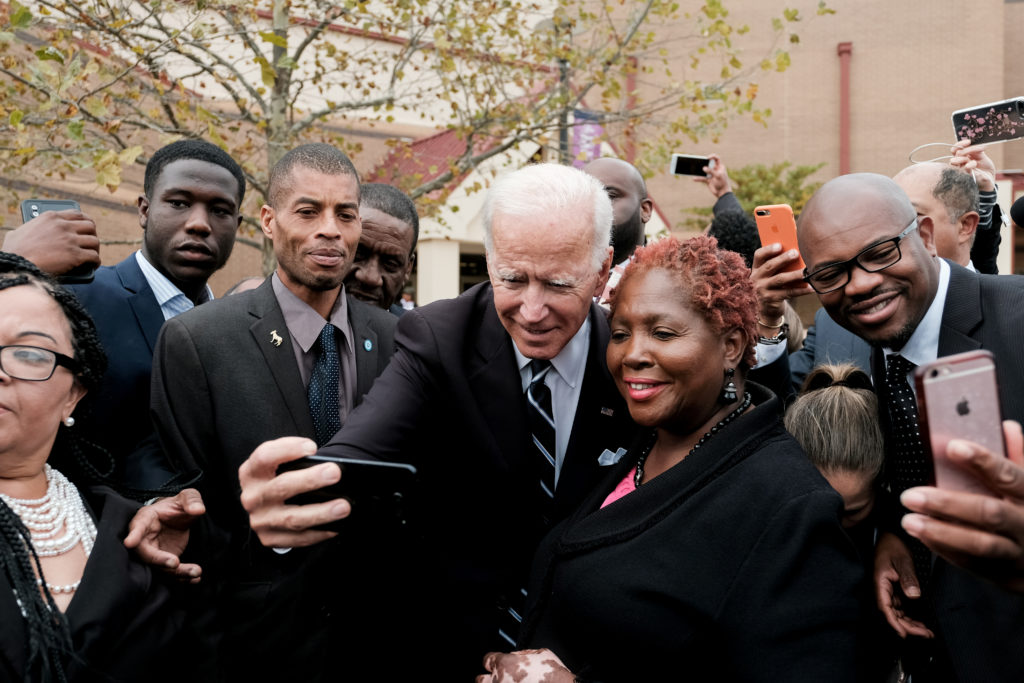 Former U.S. Vice President Joe Biden pauses to take a selfie as he departs funeral services for late U.S. Representative E...
