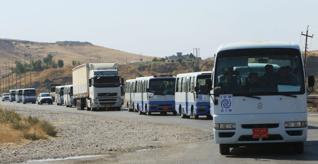 Buses carry Syrian displaced families, who fled violence after the Turkish offensive against Syria, to displacement camps ...