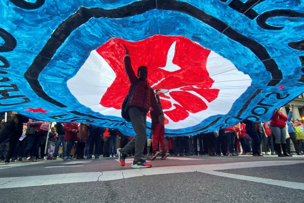 A child walks under a banner as hundreds of teachers and supporters march, days before the teacher's union was set to go o...