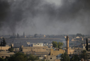 Smoke rises above the Syrian border town of Tel Abyad, as seen from Akcakale, Turkey, on October 13, 2019. Photo by Stoyan Nenov/Reuters