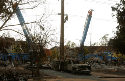 A lineman from Pacific Gas & Electric works on a power line near a neighborhood destroyed by wildfire in Santa Rosa, California, U.S., October 12, 2017. REUTERS/Jim Urquhart