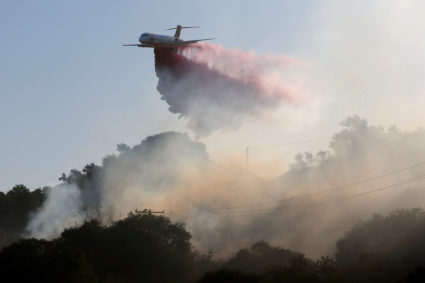 A plane drops fire retardant on the Maria Fire in the early morning in Santa Paula, California, U.S. November 1, 2019. Photo by Daniel Dreifuss/Reuters