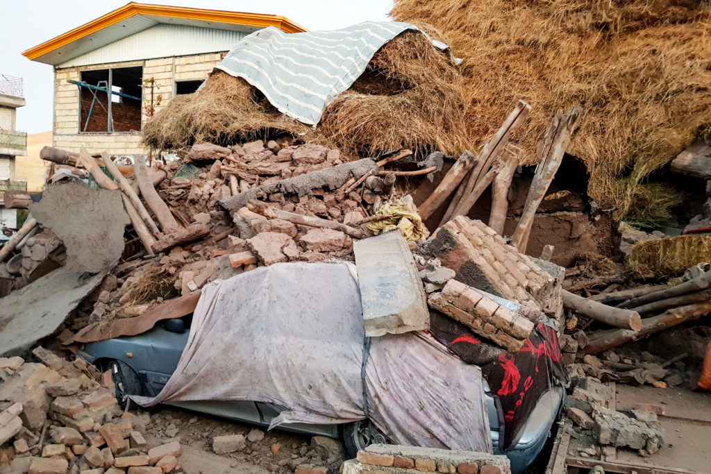 A damaged car is seen under the ruins, after an earthquake hit the Varankesh village in Eastern Azerbaijan province, north...