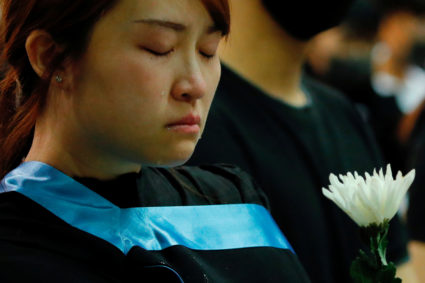 A graduate cries as she paying tribute with flower to Chow Tsz-lok, 22, a university student who fell during protests at the weekend and died early on Friday morning, at the Hong Kong University of Science and Technology, in Hong Kong, China November 8, 2019. Photo by Tyrone Siu/Reuters