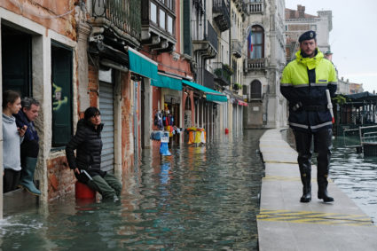 An Italian police officer patrols in a flooded street during a period of seasonal high water in Venice, Italy, November 17, 2019. Photo by Manuel Silvestri/Reuters