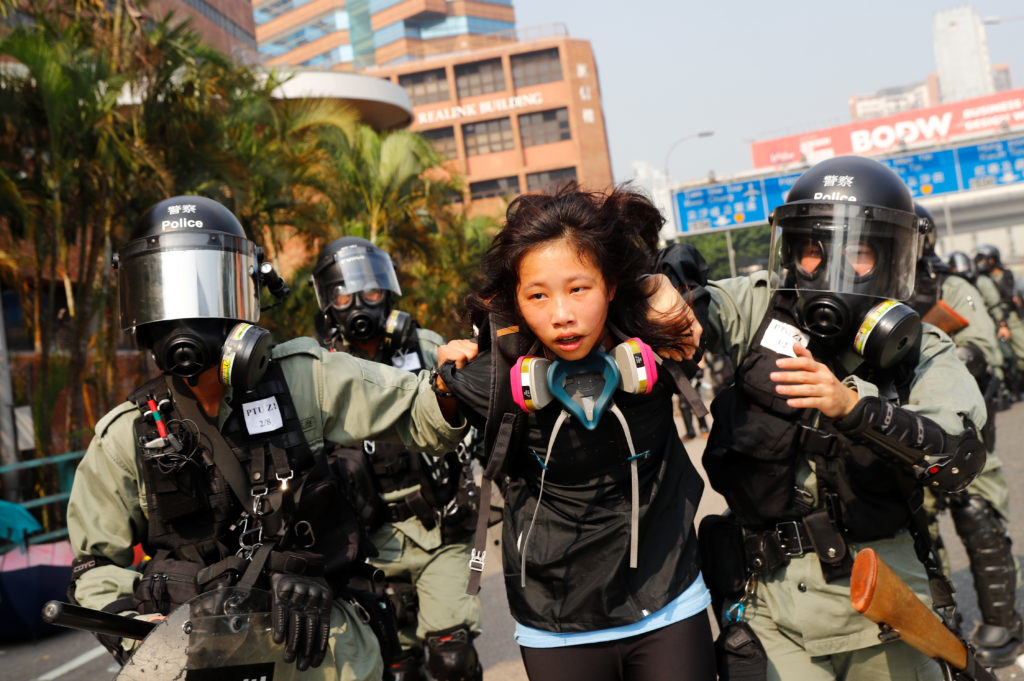 A protester is detained by riot police while attempting to leave the campus of Hong Kong Polytechnic University (PolyU) du...