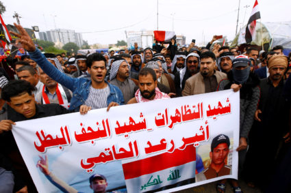 Mourners hold a banner as others carry the coffin during the funeral of a demonstrator who was killed at an anti-government protest overnight in Najaf, Iraq on November 29, 2019. Photo by Alaa al-Marjani/Reuters