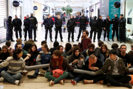 Youth for Climate activists sit-in in front of French police as they block an aisle of the Westfield Les 4 Temps shopping center during a day of protest to denounce the annual Black Friday shopping frenzy at La Defense business and financial district in Puteaux near Paris, France, November 29, 2019. Photo by Gonzalo Fuentes/Reuters,