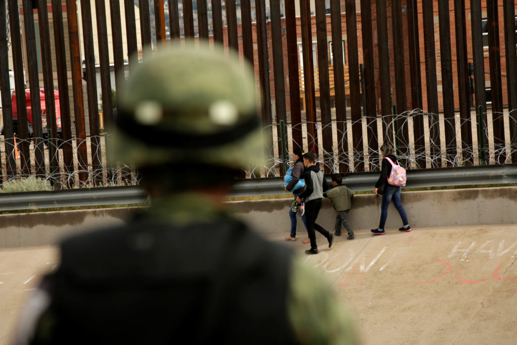 A National Guard soldier observes migrants after crossing illegally into El Paso, Texas, U.S. to turn themselves in to U.S...